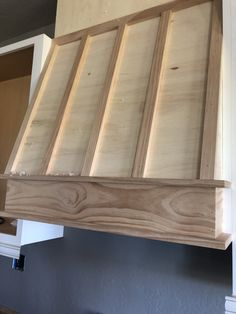 a wooden shelf mounted to the side of a kitchen wall above a stove top oven