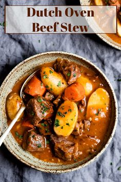 a bowl filled with stew and potatoes on top of a blue cloth next to a spoon