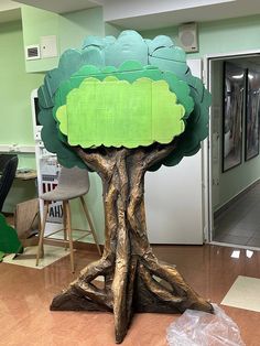 a tree made out of cardboard sitting on top of a hard wood floor