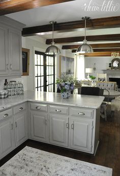 a large kitchen with white cabinets and marble counter tops, along with an island in the middle