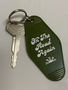 a green keychain with the words in the road again written on it