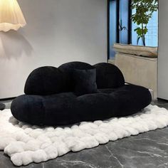 a large black and white couch sitting on top of a floor next to a lamp