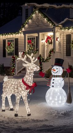 two lighted reindeer and snowman in front of a house