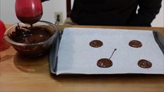 chocolate is being poured into a bowl with buttons