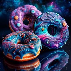 three donuts with different colors and designs are on a reflective surface in front of a galaxy background