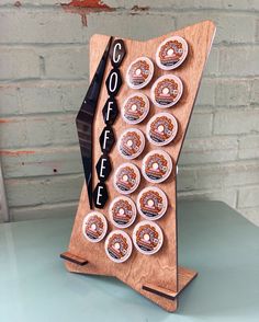 a cupcake display with doughnuts and coffee on it in front of a brick wall