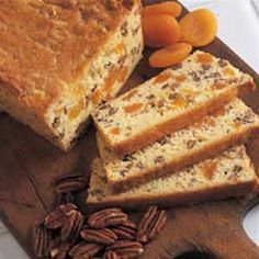 sliced loaf of bread with pecans and carrots on cutting board next to it