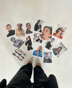 a person standing in front of a bunch of pictures on the floor with their feet up