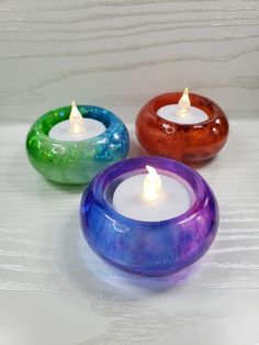 three colorful candles sitting next to each other