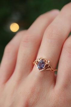 a woman's hand with a gold ring and an amethorate stone