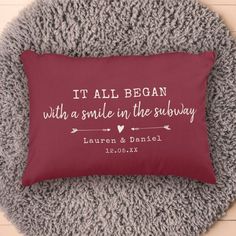 a red pillow with the words it all begin with a smile in the subway on it