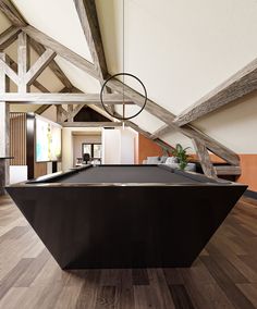 a pool table in the middle of a room with wood floors and exposed beams on the ceiling