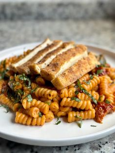 a white plate topped with pasta and grilled cheese