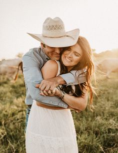 a man and woman hugging each other in a field