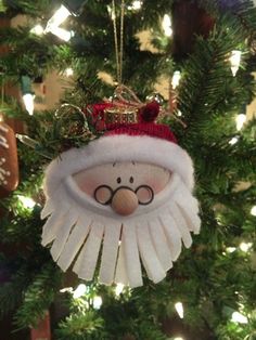 a christmas ornament hanging from a tree with glasses and a hat on it