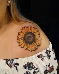 a woman's shoulder with a sunflower tattoo on her upper arm and chest