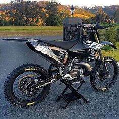 a dirt bike sitting on top of a stand in the middle of a parking lot