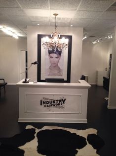 the inside of a hair salon with black and white cowhide rug on the floor