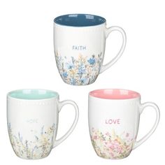 three coffee mugs with floral designs on them, one has faith and the other has love