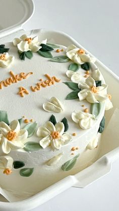 a white cake decorated with flowers and the words thank you