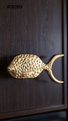 a fish shaped door handle on a wooden door