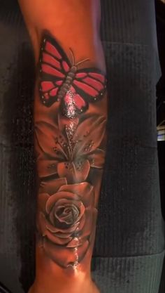 a woman's arm with a butterfly and roses on it