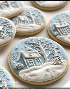 cookies decorated with icing and frosting are arranged on a white plate, surrounded by snowflakes