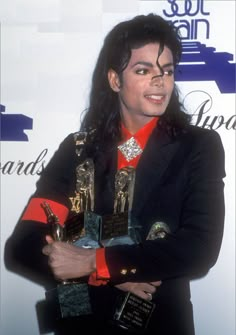 michael jackson holding two trophies in his hands