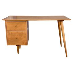 a wooden desk with two drawers on one side and an angled leg at the other end