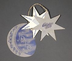 an ornament is hanging from a string on a gray background with blue and white designs