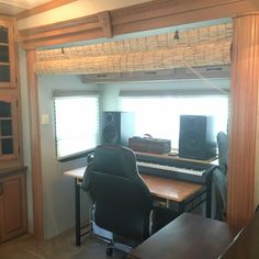 an empty room with a desk, chair and sound equipment in it's corner