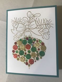 a handmade christmas ornament on a white card with green and gold foil