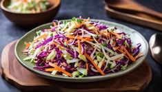 a bowl filled with coleslaw and carrots on top of a wooden cutting board