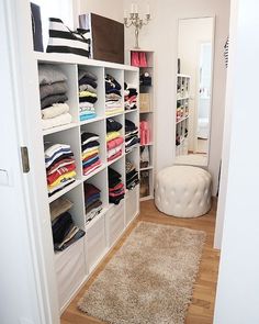 a walk in closet with lots of clothes on the shelves and carpeted flooring