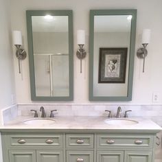 two sinks and mirrors in a bathroom with white tile flooring, green cabinetry and marble counter tops