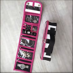 a pink and black case with various items in it next to a bag on the floor