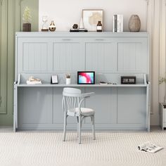 a desk with a computer monitor, keyboard and mouse on it next to a white chair