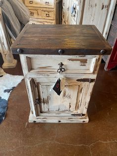 an old white cabinet with some tags on it