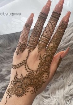 a woman's hand with henna tattoos on it