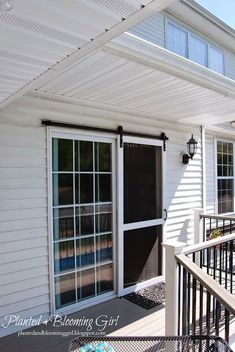 a white house with an awning over the front door and patio area on top of it