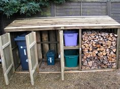 there is a firewood shed with several different types of logs in the bins