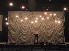 an empty theater with lights on the curtain