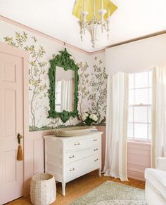 a white dresser sitting next to a mirror in a room