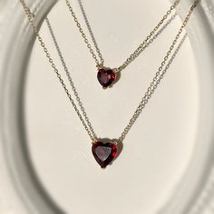 Simple, elegant, and timeless! Presenting our heart-shaped natural garnet necklace handcrafted in 9K solid gold. This style is offered in a choice of other gemstones as well. Can be paired with our Gold Heart Shape Garnet Studs. Ships within 3 business days. - Stone size: 5mm(0.5ct) or 7mm(1ct) - Stone info: natural garnet - Chain length: adjustable 16+2" - Made in 9 karat gold. - Stamp with 9K. Garnet Heart Necklace, Maroon Necklace, Garnet Heart, Double Necklace, Jewelry Board, Garnet Necklace, Jewelry Boards, Gold Heart Necklace, Garnet Stone