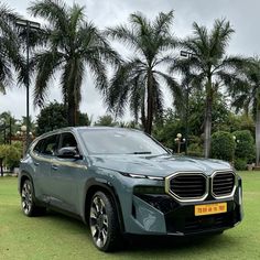 an electric car parked in front of some palm trees