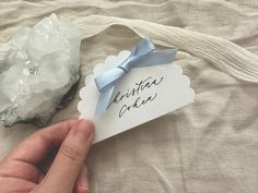 a person holding a piece of paper with writing on it next to a crystal rock