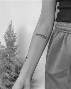 a person with a small tattoo on their arm and the word india written in cursive writing