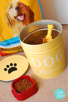 a dog bowl with a plastic spoon in it next to two bowls and a bag