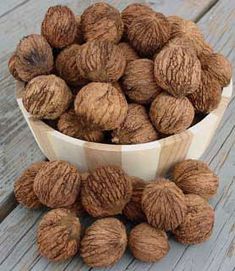 two bowls filled with walnuts on top of a wooden table