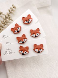 a person holding four little foxes on top of a white paper with the words simply wonderful written below them